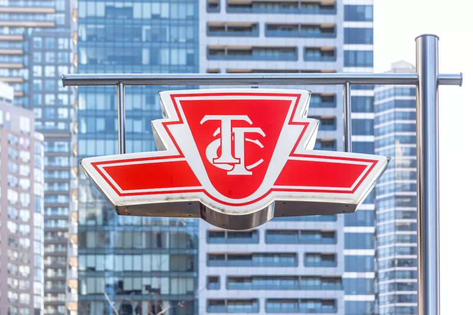 The TTC logo is visible on a sign with the high-rises of Toronto in the background.